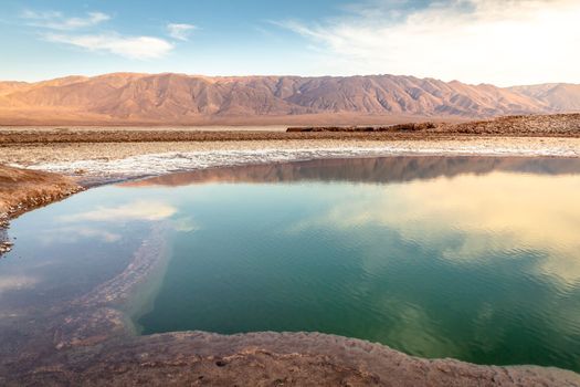Salt lake reflection and idyllic volcanic landscape at sunrise, Atacama desert, Chile border with Bolivia