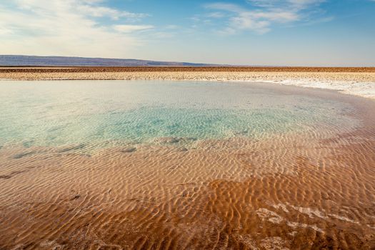 Salt lake reflection and idyllic volcanic landscape at sunrise, Atacama desert, Chile border with Bolivia