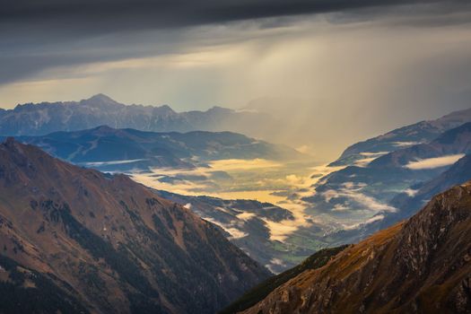 Hohe Tauern mountains and lake from above Grossglockner road at dramatic dawn, Austria