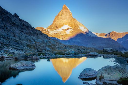Reflection of the Matterhorn on blue and placid lake at sunrise, Swiss Alps, Zermatt, Switzerland