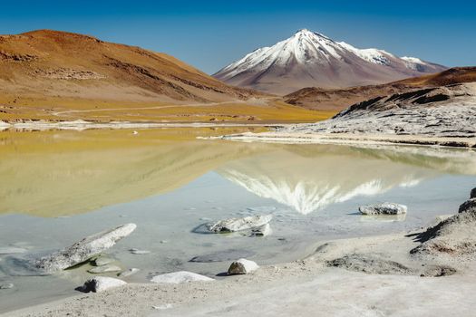 Salt lake reflection and idyllic volcanic landscape at sunrise, Atacama desert, Chile border with Bolivia