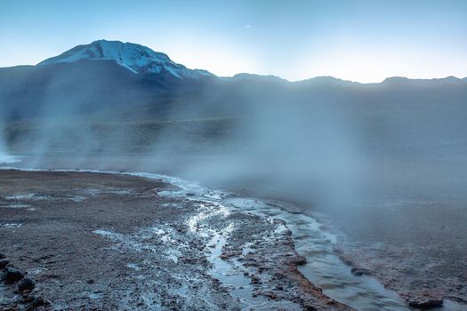 Geysers El Tatio with river and Peaceful dramatic volcanic landscape at sunrise, Atacama Desert, Chile