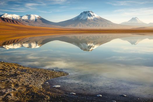 Salt lake Lejia reflection and idyllic volcanic landscape at Sunset, Atacama desert, Chile