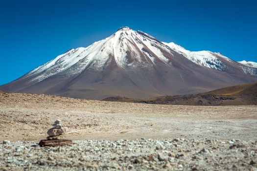 Dramatic snowcapped volcanic landscape in Piedras Rojas at sunny day, Atacama Desert, Chile