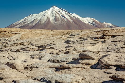 Dramatic snowcapped volcanic landscape in Piedras Rojas at sunny day, Atacama Desert, Chile