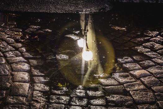 Vilnius old town street, puddle reflection illuminated at night, Lithuania, Baltic countries