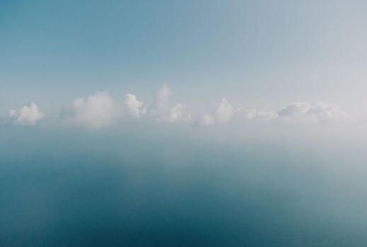 Blue sky with white clouds moving panorama summer. Sea in light of day aerial view of drone slide forward. Small waves on sea. Sunny sunset over the sea. Sun way. Horizon