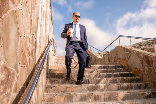 Business executive with briefcase going down the stairs.