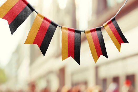 A garland of Germany national flags on an abstract blurred background.