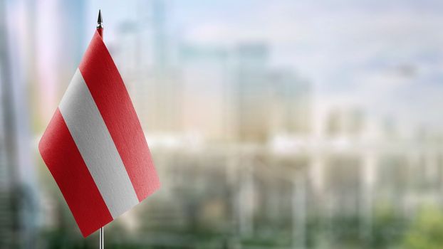 A small Austria flag on an abstract blurry background.