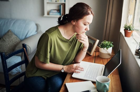 Is this a good idea. an attractive young businesswoman sitting alone in her home office and looking contemplative while using her laptop