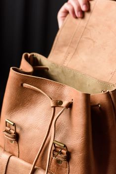 photo of a light brown leather backpack with antique and retro look. indoors photo.