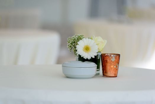 White flower on a table whit a white napkin and a lot of copy space