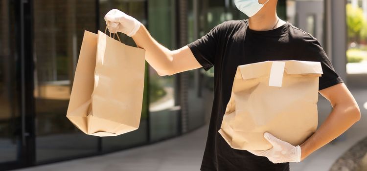 delivery guy in protective mask near the customer house, outdoors