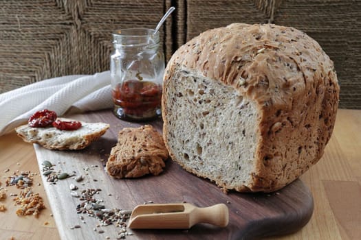 Sliced rye bread on cutting board. Whole grain rye bread with seeds. loaf of homemade whole grain bread and a cut off slice of bread. A mixture of seeds and whole grains.