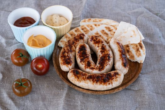Grilled sausages with sauce and vegetables. Summer rest concept