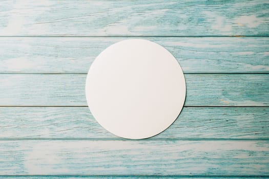 Top view blank round white paper isolated on blue wooden background, abstract geometric shapes, with copy space design element background, paper circle