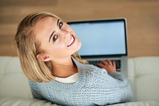 Wanna check out my blog. High angle portrait of an attractive young woman using her laptop at home
