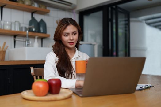 Asian Business woman working at kitchen room at home office and analyze financial report document. Accounting and Finance concept