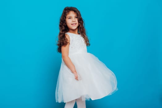little girl in white dress on a blue background