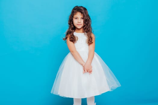 little girl in white dress on a blue background