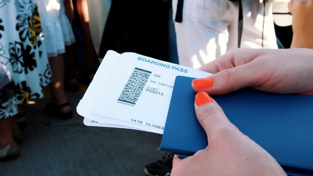 Close-up, female hands holding Airline boarding pass tickets, Boarding pass and passport at airport. High quality photo