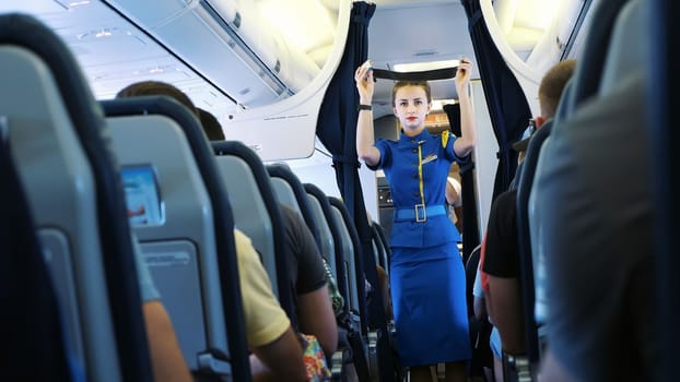AIRPORT BORYSPIL, UKRAINE - OCTOBER 24, 2018: Ukraine International Airlines. Stewardess in cabin of passenger airplane instructs passengers on safety measures in event of an emergency. High quality photo