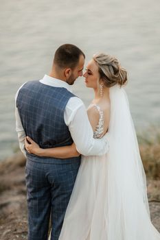 bride blonde girl and groom near the river at sunset light