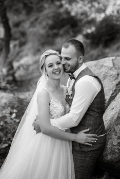 the groom and the bride are walking in the forest on a bright day