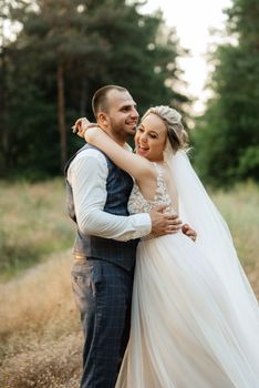 the groom and the bride are walking in the forest on a bright day