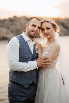 bride blonde girl and groom near the river at sunset light