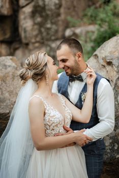 the groom and the bride are walking in the forest on a bright day