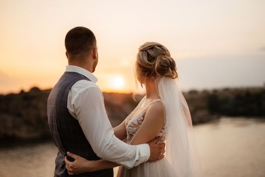 bride blonde girl and groom near the river at sunset light