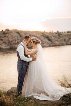 bride blonde girl and groom near the river at sunset light