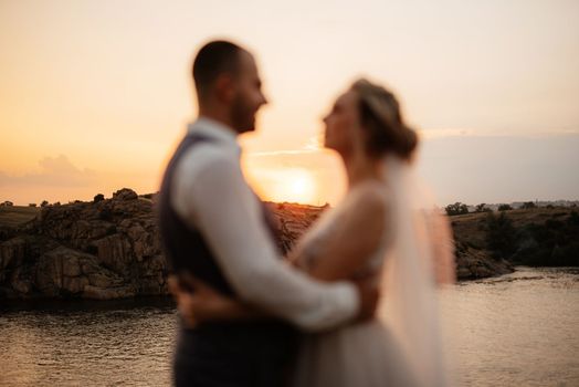 bride blonde girl and groom near the river at sunset light