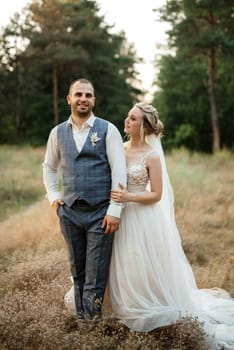 the groom and the bride are walking in the forest on a bright day
