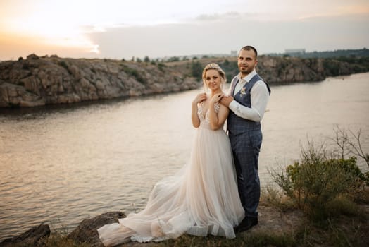 bride blonde girl and groom near the river at sunset light