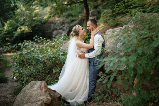 the groom and the bride are walking in the forest on a bright day