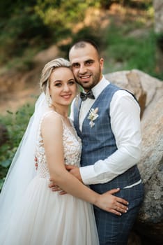 the groom and the bride are walking in the forest on a bright day