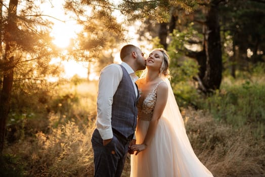 the groom and the bride are walking in the forest on a bright day