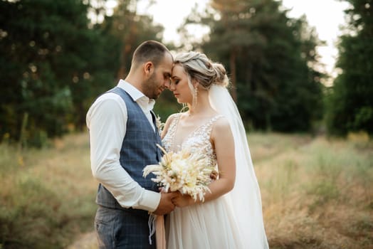 the groom and the bride are walking in the forest on a bright day