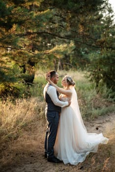 the groom and the bride are walking in the forest on a bright day