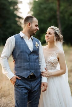 the groom and the bride are walking in the forest on a bright day