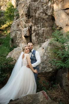 the groom and the bride are walking in the forest on a bright day