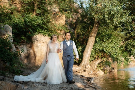 bride blonde girl and groom near the river at sunset light