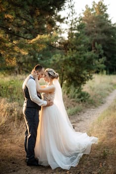 the groom and the bride are walking in the forest on a bright day