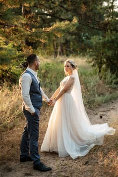 the groom and the bride are walking in the forest on a bright day