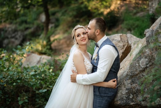 the groom and the bride are walking in the forest on a bright day