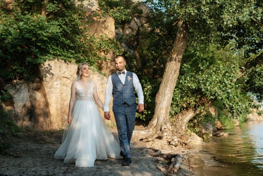 bride blonde girl and groom near the river at sunset light