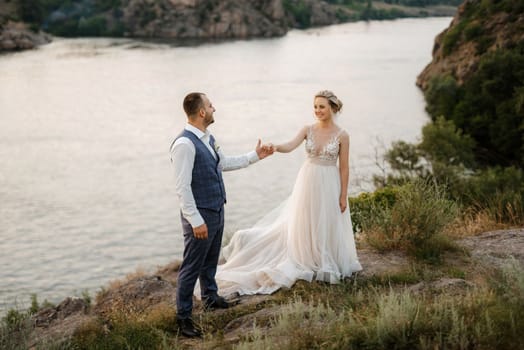 bride blonde girl and groom near the river at sunset light